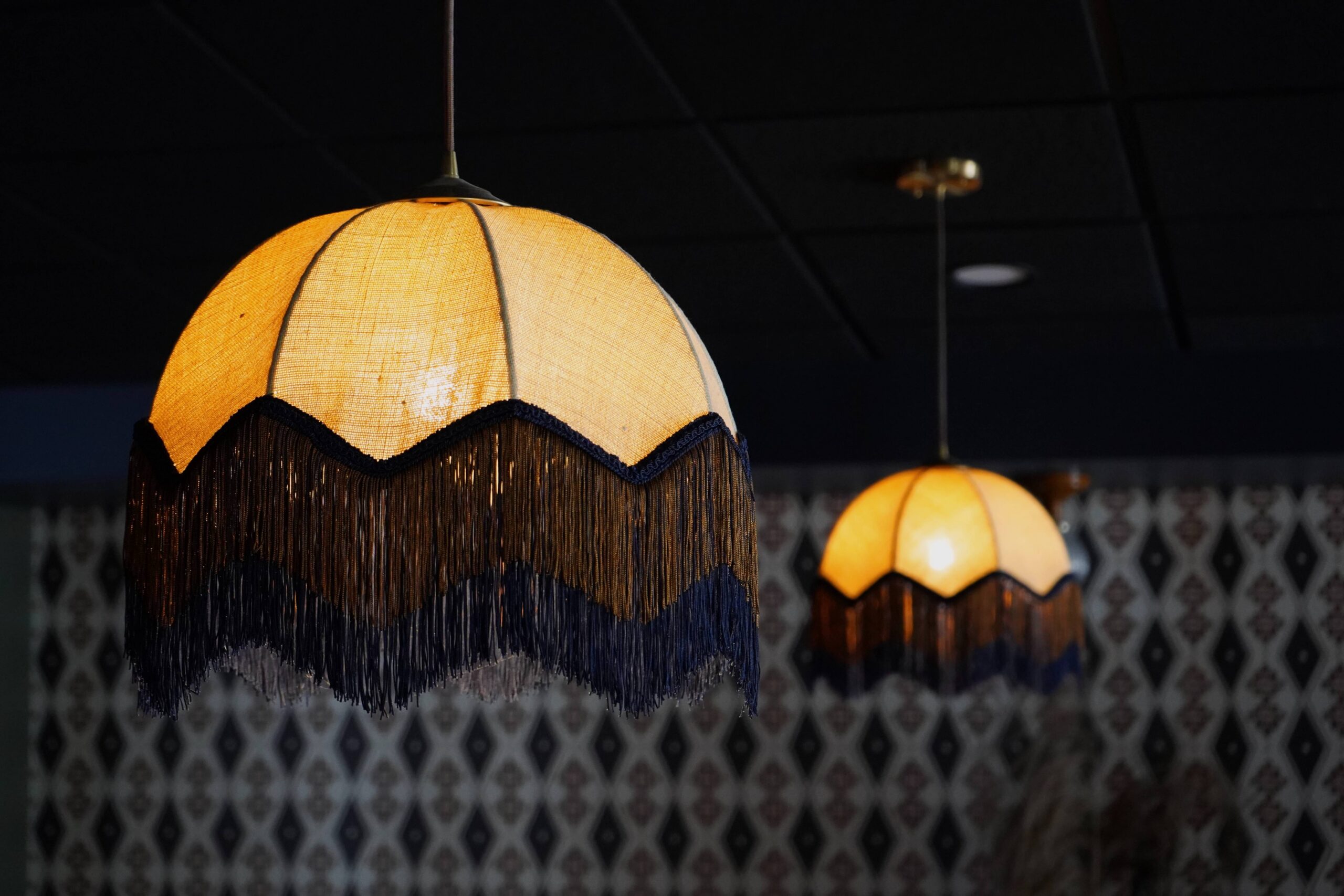 Fringed fabric pendant lights glowing over the Caldwell bar at The Buxton Hotel in Fort Collins
